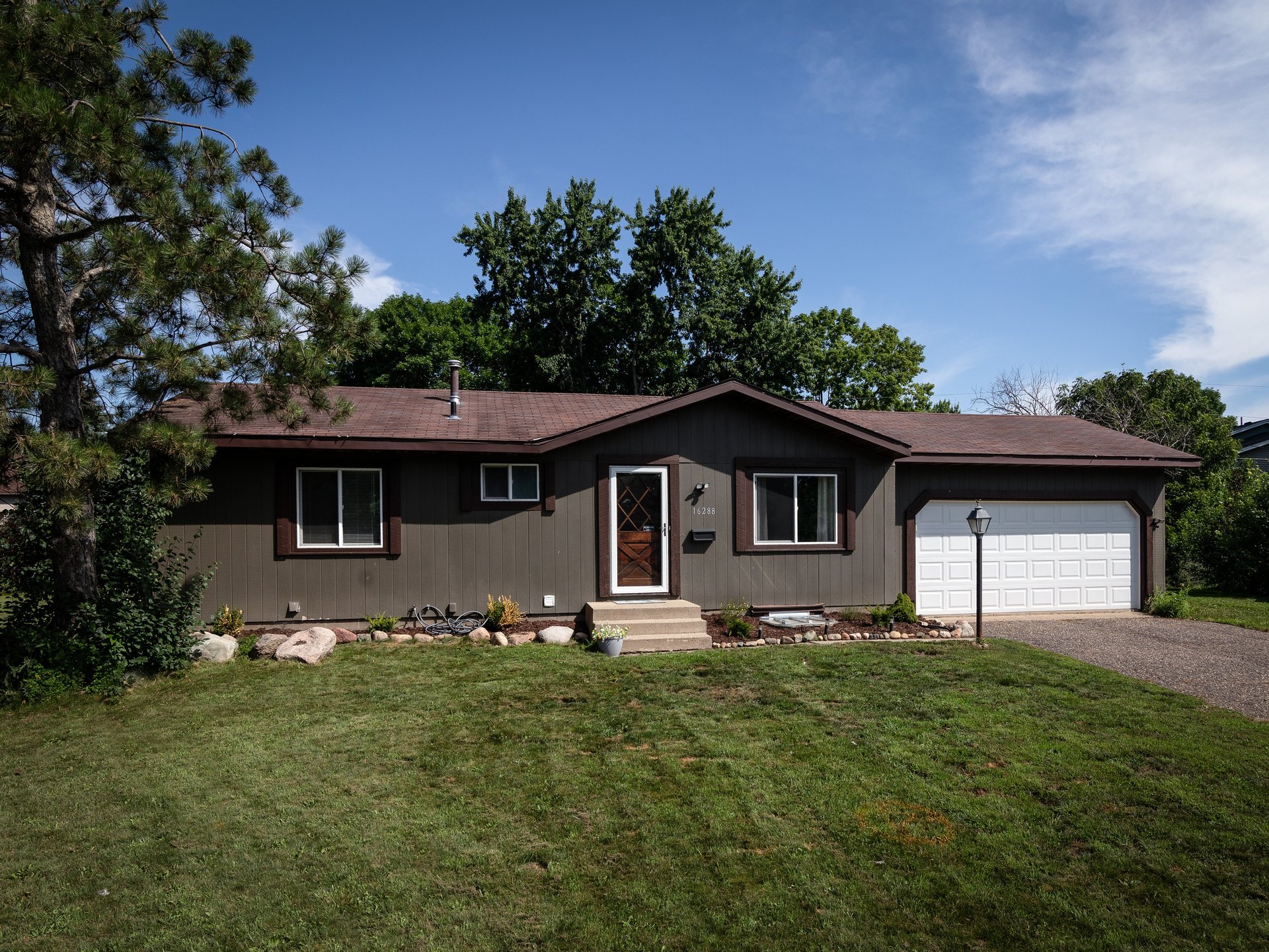 16288 Florida Way, updated rambler with rock-lined garden beds and a classic lamp post