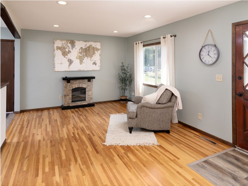 Bright living room with gleaming hardwood floors & recessed lighting