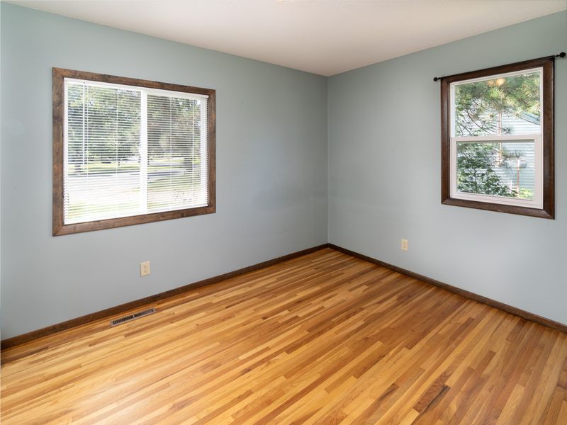 First of three main-level bedrooms with hardwood floors & windows on two walls